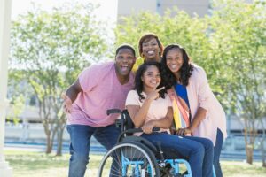 Girl in wheelchair surrounded by happy family